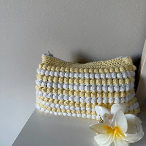Necessär - Söt handgjord necessär i gult och vitt med virkade ränder och bubblig struktur. Perfekt för småsaker eller smink.
