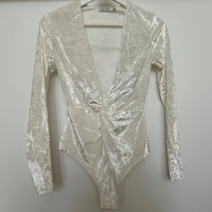 Vit body i velvet NLY - Supersnygg vit body i velvet från Nelly i storlek XS. Använd ett fåtal gånger, plagget är i mycket bra skick 🌸