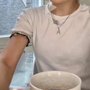 Vit ribbad t-shirt med svarta detaljer - Säljer en superfin och stilren topp från Zara i vitt med svarta dekorativa detaljer vid ärmsluten. Ribbat, mjukt material som sitter bekvämt och passar till mycket. Passar både till vardags och lite mer uppklätt. Använd fåtal gånger och är princip i nytt skick. Säljs endast då den inte kommer till användning 🩷