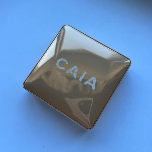 CAIA highlighter - Portofino - Säljer en highlighter från CAIA i en lyxig guldig förpackning. Produkten har en skimrande, champagnefärgad ton och kommer i en fyrkantig dosa med spegel. Perfekt för att ge glow till ansiktet. Sparsamt använd.