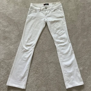 Lågmidjade vita jeans från Guess  - Väldigt lågmidjade vita jeans från Guess i bra skick. De är flared i passformen. Skriv vid frågor.
