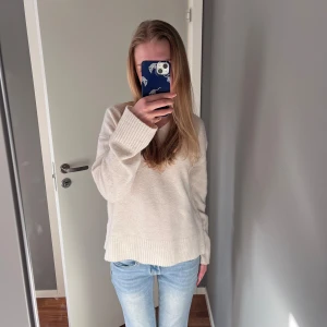 Beige stickad v-ringad tröja - Mysig beige stickad tröja med v-ringning och långa ärmar. Tröjan har breda ribbade muddar vid ärmslut och nederkant, perfekt för lager-på-lager. Enkel och stilren design som passar till det mesta. Priset kan förhandlas :)