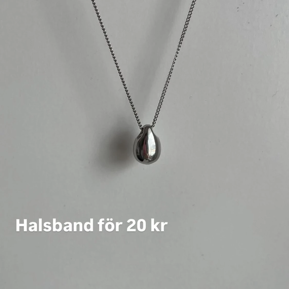 Silverfärgat halsband med droppformad berlock