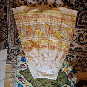 Blommig vintagekjol i bomull - Säljer en retro blommig kjol med orange, gula och vita blommor på cremefärgad botten. Kjolen har en A-linjeform och resår i midjan. Perfekt för dig som gillar färgglada och unika plagg.