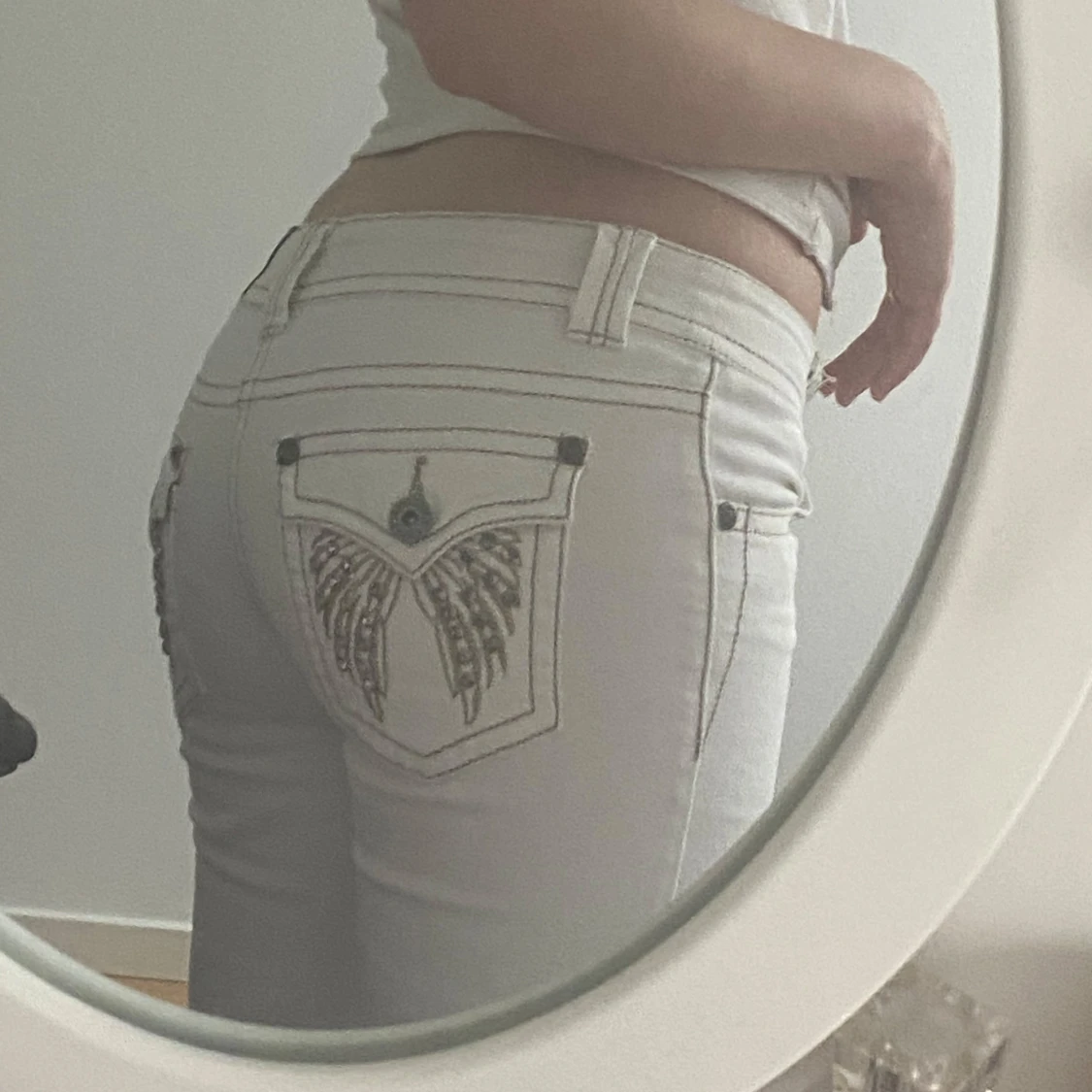 Vita lågmidjade flared jeansbyxor med broderade fickor