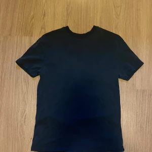 Svart t-shirt från RVLS - En stilren svart t-shirt från RVLS i 100% bomull. Klassisk rund halsringning och korta ärmar. Perfekt basplagg för garderoben och enkel att matcha med andra kläder.