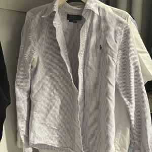 Ralph lauren skjorta  - Klassisk skjorta från Polo Ralph Lauren i vitt och blått med smala ränder. Bra skick!