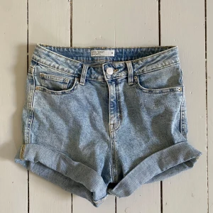 Blåa jeansshorts  - Snygga högmidjade blåa jeans. De går att vika ner och upp för länge man vill ha.