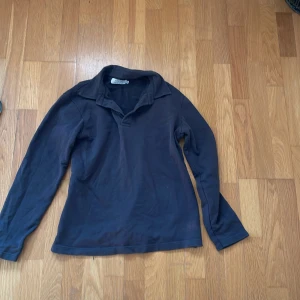 Mörkblå långärmad pikétröja från Ljung - Säljer en stilren mörkblå långärmad pikétröja från Ljung. Tröjan har klassisk krage och är tillverkad i mjuk bomull, perfekt för en avslappnad men snygg look.