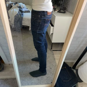 Mörkblå Nudie jeans - Säljer ett par mörkblåa Nudie jeans🤩Storlek: 28/30. Skick: 9.2/10. Sitter perfekt och har en snygg färg! Skriv till mig om du har några frågor eller funderingar😁🤝