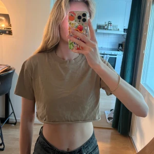 Beige/ljusbrun croppad t-shirt från Bik Bok - Säljer en beige/ljusbrun croppad t-shirt från Bik Bok. T-shirten har rund halsringning och korta ärmar. Perfekt till jeans eller kjol för en avslappnad stil. Superenkel att matcha med andra plagg!