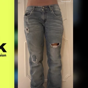 Ljusblå slitna jeans från Hugo Boss - Ljusblå lowwaist jeans från Hugo Boss med slitningar och hål på båda benen. Klassisk femficksmodell med normal passform och knappgylf. Perfekta för en avslappnad och trendig look. 