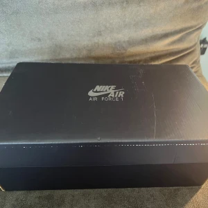 Nike Air Force 1 helvita sneakers - Säljer ett par klassiska helvita Nike Air Force 1 sneakers. Skorna har en stilren design med vit ovandel, vita snören och diskret rutmönster på vissa partier. Perfekta för dig som gillar en clean och tidlös look. Har dessutom inte använt skorna eftersom jag köpte fel storlek. Skriv gärna om ni är intresserade🤍