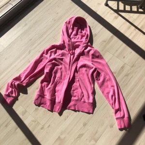 Rosa hoodie med dragkedja - Säljer en mysig rosa hoodie med dragkedja och huva. Perfekt för en avslappnad stil. Den har långa ärmar och ribbade muddar vid ärmslut och nederkant.