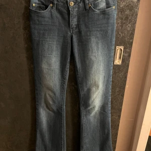 Blå bootcut jeans från Rainbow - Snygga blå bootcut jeans från Rainbow. De har en klassisk femficksdesign och en bekväm passform. Perfekta för en avslappnad stil med en touch av retro.