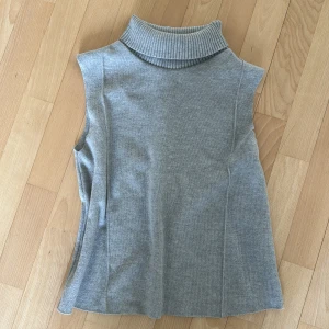Fin grå ärmlös polotopp med krage ZARA storlek S/Xs - Säljer en stilren grå ärmlös polotopp med krage från Zara. Enkelt att matcha med olika outfits. Bra skick💗