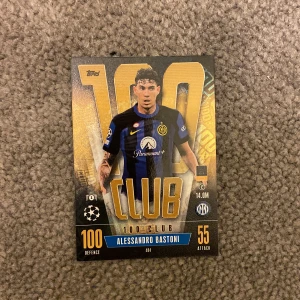 Match Attax fotbollskort - Alessandro Bastoni - Match Attax fotbollskort med Alessandro Bastoni från FC Internazionale Milano. Kortet har en elegant design med guld och svart text, och visar Bastoni i lagets blåsvarta matchtröja. Perfekt för samlare och fotbollsfans!
