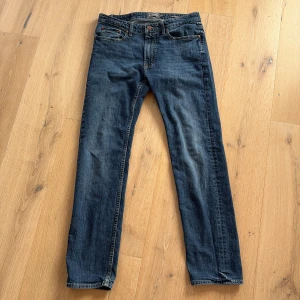 Nevada Blå jeans från Dressmann - Säljer ett par Nevada Stretch jeans från Dressmann med regular fit. Jeansen har en traditionell femficksdesign och stängs med dragkedja och knapp. 
