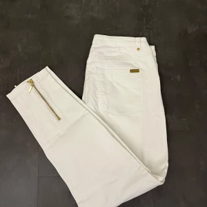 Vita jeans från H&M - Snygga vita jeans från H&M med gulddetaljer. Byxorna har en dragkedja vid fickan och längst ner. Stilrena. ❣️