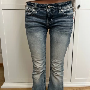 Blå bootcut jeans med broderad bakficka - Snygga blå bootcut jeans med design på bakfickorna från märket miss me. Knappt använda
