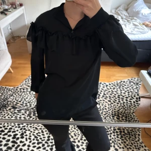 Svart blus med volangdetalj - Sååå fin och classy blus med volang, strl 40 men känns som 36/38 🩷🩷 superfint skick 
