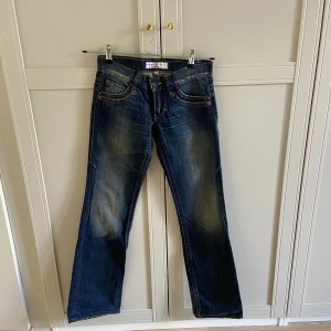 Blå jeans från Freeman T. Porter - Asballa blå jeans från Freeman T. Porter med svin snygg och unik tvätt, mindre slitna detaljer och knappar på bakfickorna. Dröm jeans men de passade tyvärr inte mina höfter😬de har inga synliga defekter men de är slitna längst ner som del av designen! De är storlek 25 men passade inte mig som brukar ha 25-26 (167cm lång, fick på dom men kunde ej knäppa) Därför skulle jag säga att de är mer 24 eller 25 om man har mindre höfter(om man vill ha dom mer baggy kan de va för mindre) nypris ca 1200kr