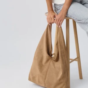 INTRESSEKOLL på denna väska! - Intressekoll på denna snygga rymliga beige/bruna axelväskan i mjukt mockamaterial. Perfekt för att bära med sig alla nödvändigheter med stil. Enkel och stilren design som passar till många olika outfits. Använd fåtalgånger och är därmed i bra skick! 