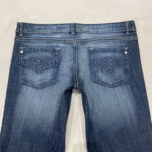 Lågmidjade bootcut jeans med detaljer💕 - Midja 44x2 cm plus stretch, gren 21.5 cm och innerben 74 cm💕Jae 169 o xs-s o de är alldeles förstora för mig därför sitter de konstigt fastän jag håller in i midja, rumpa och lår🥲tar därför inte fler bilder med dem på då det blir missvisande. Märkta storlek 14 = storlek L/42 men vet inte hur accurate det är så använd gärna måtten!!
