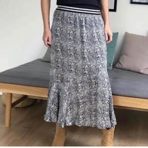 Mönstrad kjol från Prepair M - Snygg mönstrad kjol från Prepair med elastisk midja och randig detalj. Kjolen har ett unikt mönster i blått och beige som ger en stilren look. Perfekt för att lyfta din outfit!