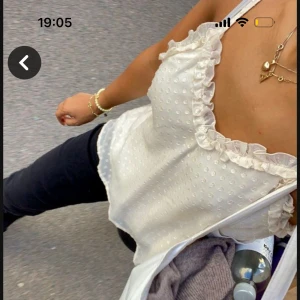 Vit prickig linnetopp med volangdetaljer - Säljer en söt vit linnetopp med prickigt mönster och volangdetaljer vid axlarna. Toppen är ärmlös och har en luftig passform. I strolek m. OBS! Första bilden är lånad.