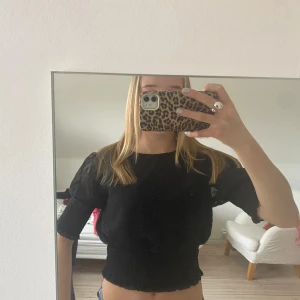 Svart blus med trekvartsärm - Säljer en stilren svart blus med trekvartsärm och diskret prickigt mönster. Blusen har en elastisk midja och är perfekt för en chic look. Passar bra till både jeans och kjol.