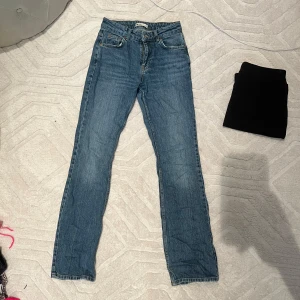 Blå jeans från Gina Tricot - Snygga blå jeans från Gina Tricot med klassisk femficksdesign och knappgylf. Perfekta för en avslappnad stil.