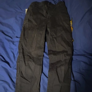 Mörkblåa chinos byxor från H&M - Säljer ett par mörkblåa chinos byxor från H&M. De har en normal passform och är tillverkade i ett bekvämt material. Perfekta för en stilren look. Andända 1 gång. Säljer pga inte rockar dom längre.