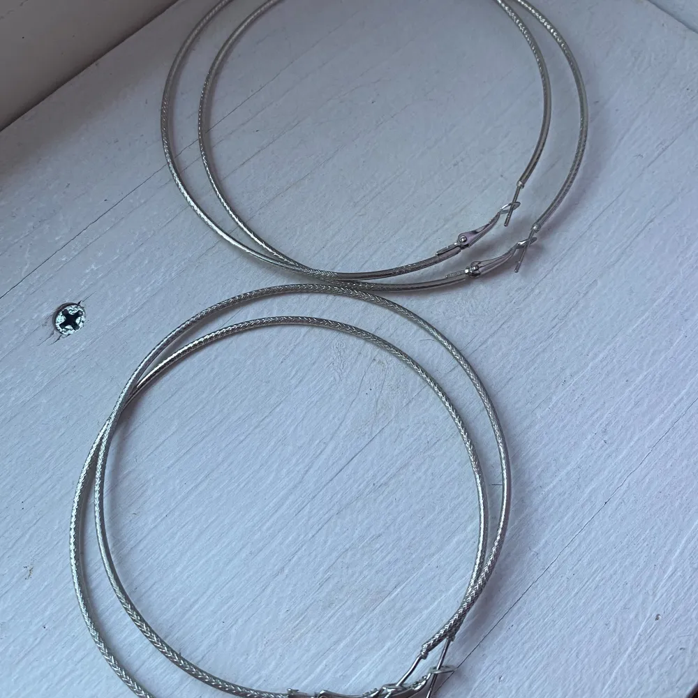 2 par silvriga örhängen, exakt likadana bara att det ena paret är en storlek mindre (se bild 2). Väldigt fina och sitter snyggt! Bara använt det ena paret några fåtal gånger så i väldigt bra skick!. Asusteet.