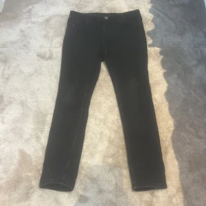 Svarta skinny jeans från Denim, strl 152 - Svarta skinny fit jeans från Denim i storlek 152. Klassisk femficksmodell med dragkedja och knapp framtill. Jeansen har smal passform och är tillverkade i stretchigt denimtyg för en tajt look.