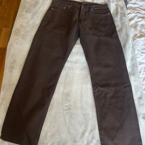 Bruna raka jeans från weekday - Säljer ett par bruna jeans från Levi's med klassisk femficksdesign och raka ben. Jeansen har en enkel look med kopparfärgade nitar och normal passform. Perfekta för dig som gillar stilrena och tidlösa byxor.
