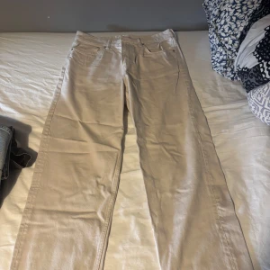 Grå/beigea raka byxor  - Snygga grå/beige jeans som jag tyvärr inte använt särskilt mycket. Jeansen är använda runt 10 gånger och har inga skador eller dylikt förutom lite smuts på vänster ben som man kan se på bilden. Går säkert bort i en tvätt med lite vanish på eller liknande. Storlek 32/32