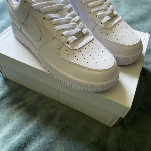 Nike Air Force 1 - Klassiska Nike Air Force 1 i helvitt skinn med vit sula och snörning. Perfekta för dig som vill ha en clean och stilren sneaker till vardags. Storlek 42.5, hör av er vid minsta intresse.