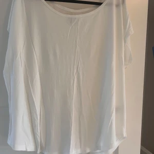 Vit t-shirt från Crocker Apparel - Vit t-shirt från Crocker Apparel i storlek L. Oversized passform med rund halsringning och korta ärmar. Tillverkad i en mjuk mix av bomull, modal och polyester som känns skön mot huden. Perfekt basic-plagg att ha i garderoben.