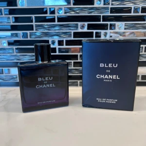 Bleu de Chanel Eau de Parfum 100ml - Bleu de Chanel Eau de Parfum för herr, 100 ml. Flaskan är stilren och mörkblå med silverdetaljer och klassisk Chanel-logga på korken. Kommer med originalkartong i matchande blått. En ikonisk doft med maskulin och fräsch känsla.