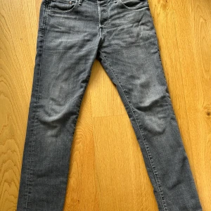 Grå slim straight jeans 30/32 - Snygga grå jeans i slim straight fit med klassisk femficksdesign. Jeansen har en rak men smal passform och är tillverkade i mjukt denimtyg. Perfekta för dig som gillar en stilren look med lite edge.
