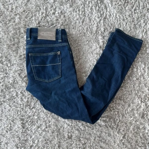 Blå jeans från Tramarossa - Snygga blå jeans från Tramarossa med klassisk femficksdesign och kontrastsömmar. Byxorna har knäppning med silverfärgade knappar och broderad text på insidan. Tillverkade i mjukt denimtyg med italiensk känsla, modell Leonardo . Kan gå ner vid pris vid snabbaffär 