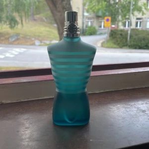 Jean Paul Gaultier Le Male EdT 75ml - Jean Paul Gaultier Le Male Eau de Toilette 75ml. Flaskan har en ikonisk design i form av en manlig torso i frostat turkost glas med ljusblå ränder och silverfärgad spraykork. En klassisk och populär herrdoft med fräsch och maskulin känsla.
