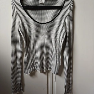 Randig långärmad tröja från H&M - Säljer en svartvit randig långärmad tröja från H&M. Tröjan är ribbad, har en rundad halsringning och slits vid ärmsluten. Materialet är stretchigt och känns mjukt mot huden, perfekt för lager-på-lager. Passformen är normal.