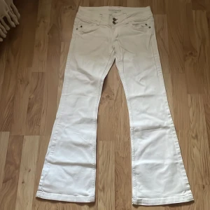 Vita lågmidjade bootcut jeans W28 L30 - Snygga lågmidjade vita jeans med bootcut passform. Märket är topshop Moto och de är köpta på en secondhand.💕Midjemåttet är ca 36cm och längden från topp till botten är ca 98cm❤️De är lite för långa på mig som är ca 160cm💖💖De är i nytt skick och ser inte något tecken på användning alls.🙌🏻