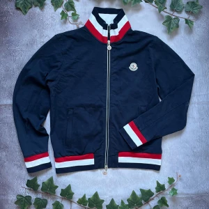 Moncler Manglia Cardigan (Äkta) - Moncler Manglia Cardigan 🎨 Färg: Mörkblå, Röd och Vit 📏 Storlek: M men passar S 📐 Mått: Fråga om det önskas ♻️ Skick: 9/10 🧵 Material: 100% bomull  ‼️Skickas dagen efter köpet genomförs‼️