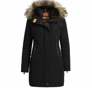 Svart parkasjacka med fuskpäls - Snygg svart parkasjacka från Parajumpers med lång passform och huva med fuskpäls. Jackan har dragkedja framtill, flera fickor och en patch på ärmen. Perfekt för kalla vinterdagar och riktigt varm med sin fodring. Fickorna är trasiga men annars bra skick.