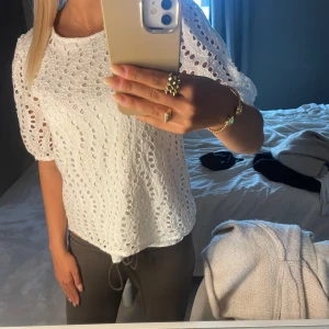 Vit broderad blus från JDY - Superfin vit blus från JDY i storlek XS. Blusen har broderade hålmönster, puffiga korta ärmar och rund halsringning.