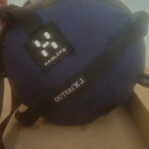 Blå sovsäck från Haglöfs Outback J. - Säljer en blå sovsäck från Haglöfs, modell Outback J. Säcken har svarta detaljer och justerbara remmar. Perfekt för dig som gillar äventyr