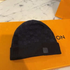  Louis Vuitton mössa  - Mörkblå  mössa från Louis Vuitton med diskret rutmönster .